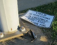 Demolished sign about yielding to pedestrians